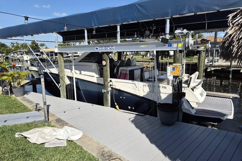 Slide: The Image of 2013 Azimut 36 yacht docked under a covered marina with lush surroundings. - 3
