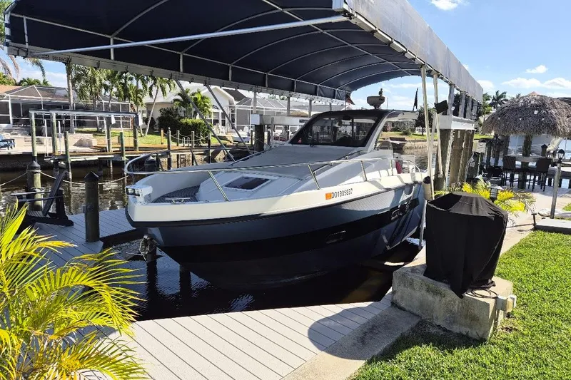 Slide: The Image of 2013 Azimut 36 yacht docked under a canopy in a sunny marina setting. - 4