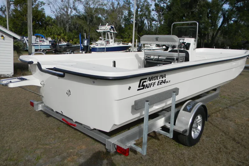 Slide: The Image of 2026 Carolina Skiff E24 DLX CC boat on trailer, parked outdoors. - 10