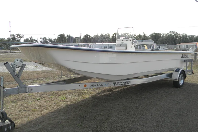 Slide: The Image of 2026 Carolina Skiff E24 DLX CC boat on trailer, displayed outdoors. - 4