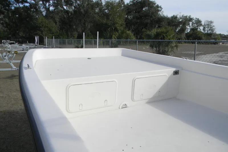 Slide: The Image of 2026 Carolina Skiff E24 DLX CC boat deck with storage compartments, outdoors. - 6