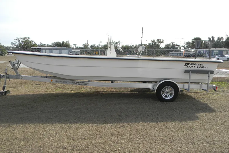 Slide: The Image of 2026 Carolina Skiff E24 DLX CC boat on trailer, parked outdoors. - 8