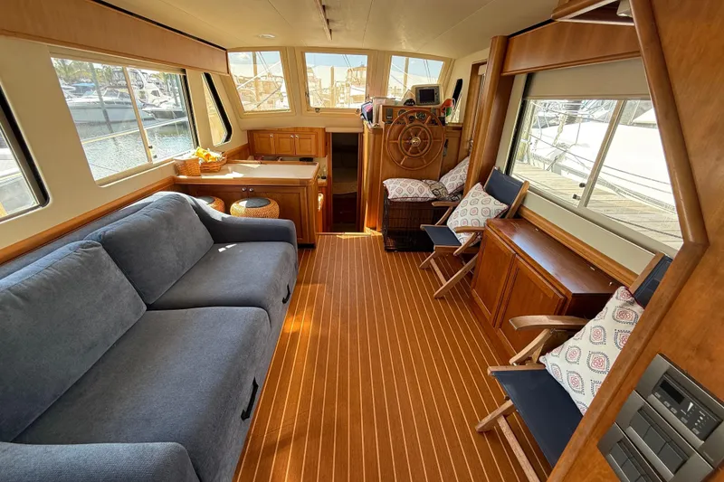 Slide: The Image of 2006 Mainship 34 Trawler interior with beige cushioned seating and protective canopy. - 16