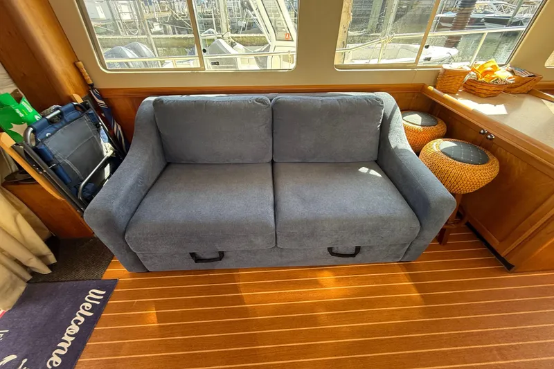 Slide: The Image of 2006 Mainship 34 Trawler interior with seating and helm, enclosed by clear canopy. - 17