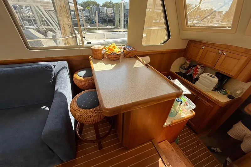 Slide: The Image of Interior of 2006 Mainship 34 Trawler with cozy seating and wooden accents. - 18