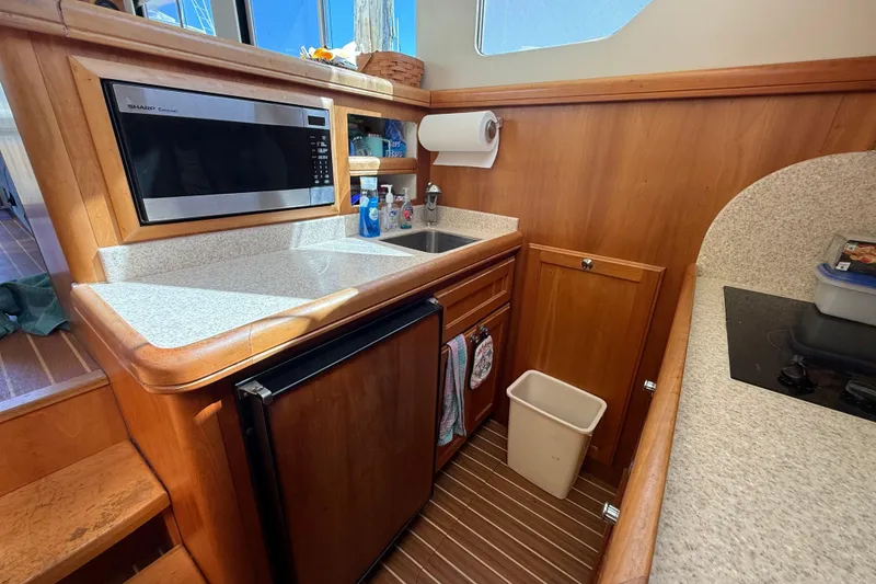 Slide: The Image of Interior of 2006 Mainship 34 Trawler with blue sofa and wooden flooring. - 19