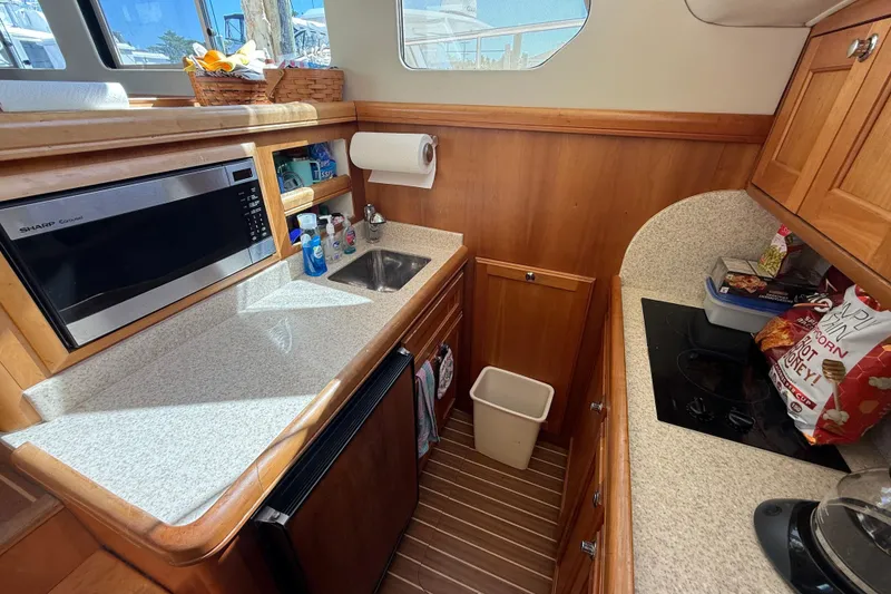 Slide: The Image of Interior of 2006 Mainship 34 Trawler with dining area and kitchen amenities. - 20