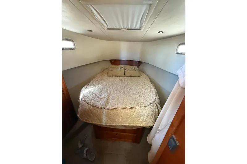 Slide: The Image of Wooden floor of 2006 Mainship 34 Trawler, featuring striped design and storage hatch. - 24