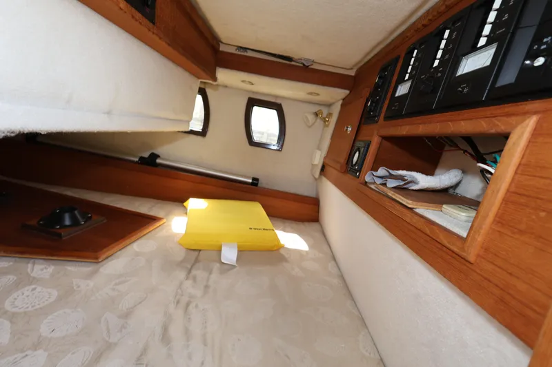 Slide: The Image of 2015 Ranger Tugs R-29 S cabin interior with control panels and storage. - 17