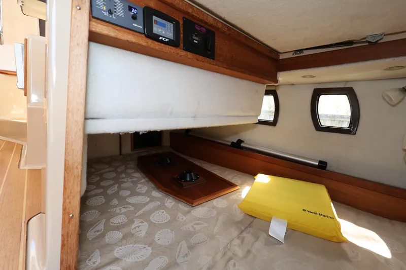 Slide: The Image of 2015 Ranger Tugs R-29 S cabin interior with cozy sleeping area and control panel. - 18