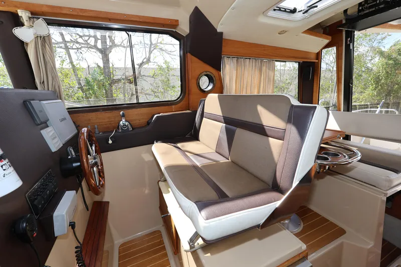 Slide: The Image of 2015 Ranger Tugs R-29 S interior with helm, seating, and wood accents. - 22