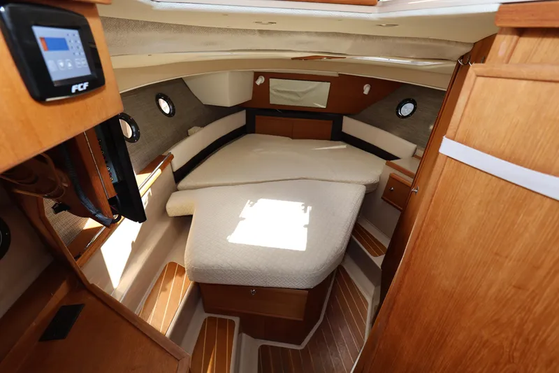 Slide: The Image of 2015 Ranger Tugs R-29 S cabin interior with cozy bed and wooden accents. - 24