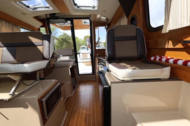 Slide: The Image of Interior of 2015 Ranger Tugs R-29 S boat with seating and wood accents. - 27