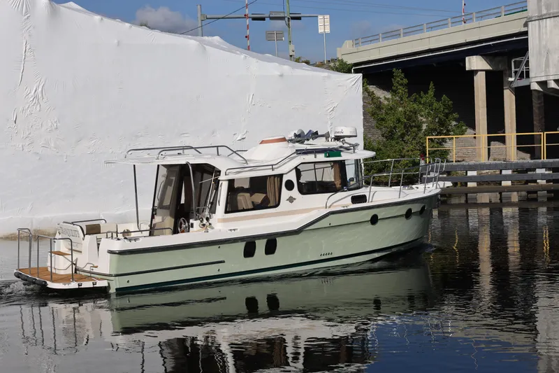 Slide: The Image of 2015 Ranger Tugs R-29 S boat docked near a bridge on calm water. - 4