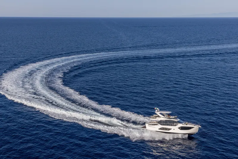 Slide: The Image of 2025 Absolute 56 FLY yacht cruising on open sea, leaving a curved wake. - 3