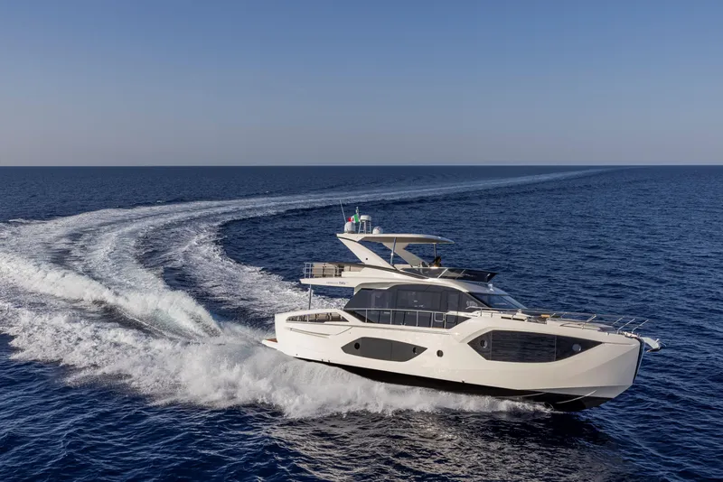 Slide: The Image of 2025 Absolute 56 FLY yacht cruising on open sea, leaving a wake behind. - 4