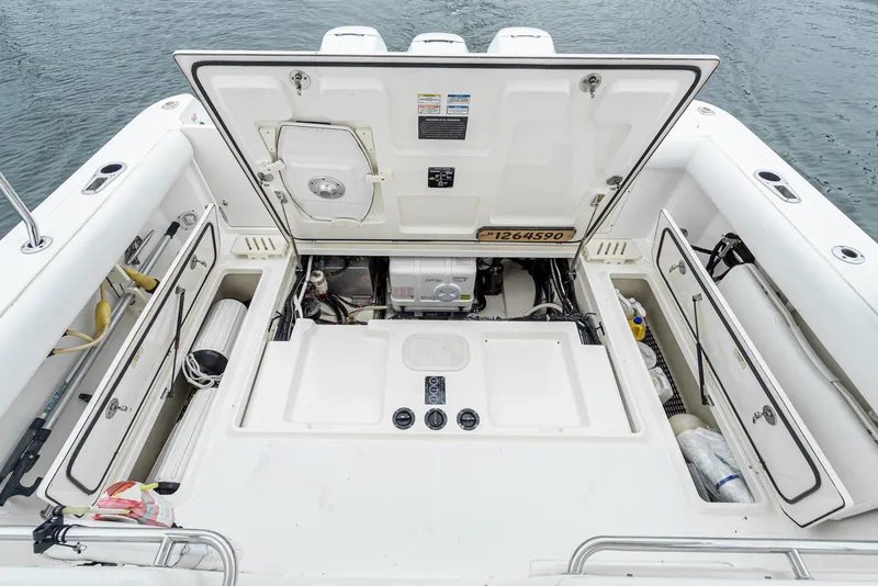 Slide: The Image of 2008 Boston Whaler 345 Conquest boat engine compartment with open hatch, showcasing storage and equipment. - 25