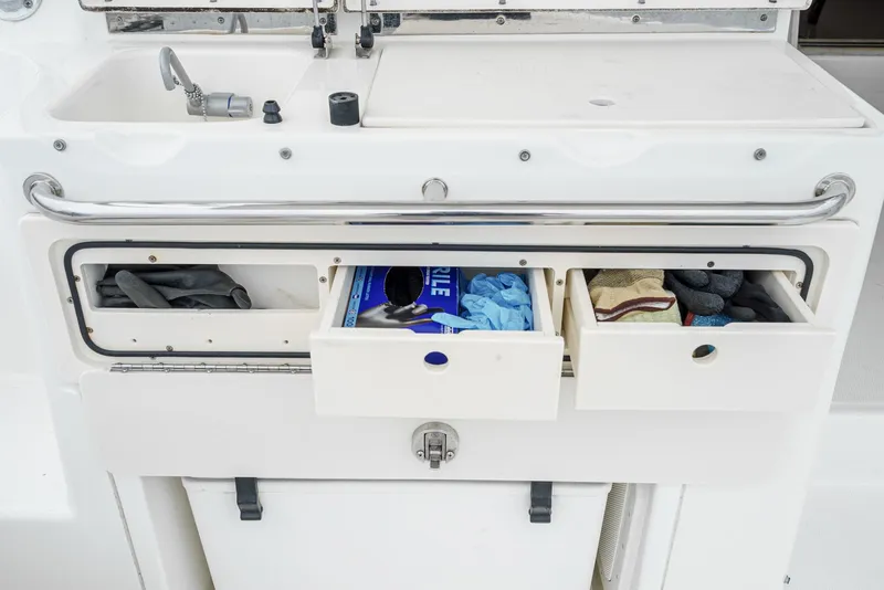 Slide: The Image of 2008 Boston Whaler 345 Conquest boat storage drawers with various items. - 30