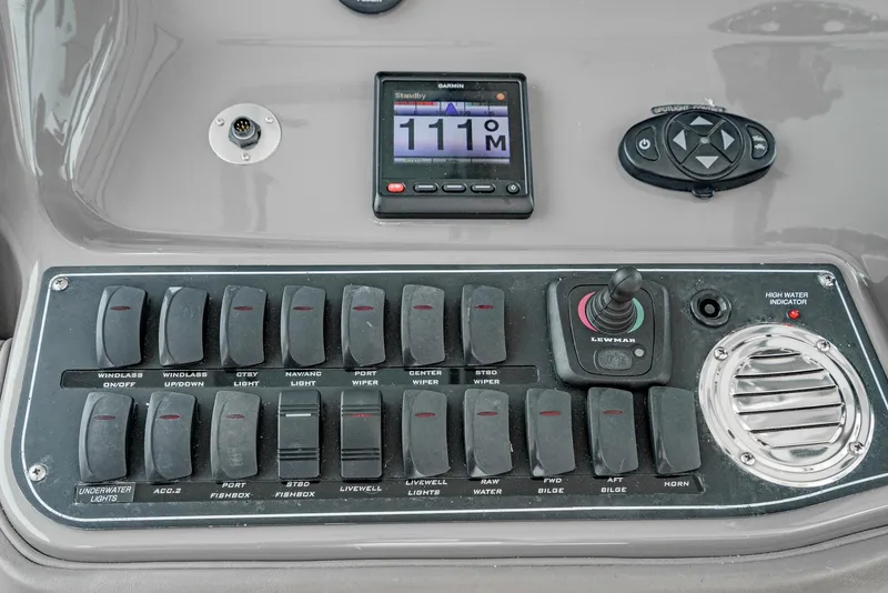 Slide: The Image of Control panel of a 2008 Boston Whaler 345 Conquest boat with switches and display. - 39