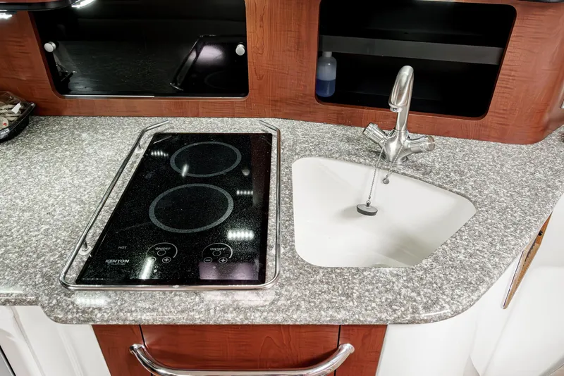 Slide: The Image of 2008 Boston Whaler 345 Conquest kitchen with stove and sink, featuring granite countertop. - 47