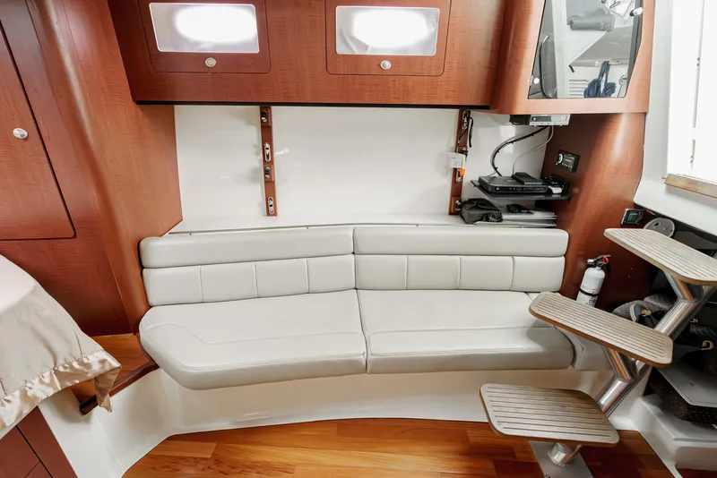 Slide: The Image of Interior of 2008 Boston Whaler 345 Conquest with beige seating and wooden accents. - 48