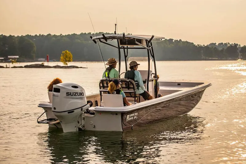 Slide: The Image of Manufacturer Provided Image: 2026 Carolina Skiff 25 LS boat cruising on a serene lake at sunset. - 7