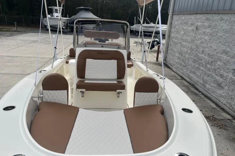 Slide: The Image of 2026 Pioneer 180 Sportfish boat with brown and white seating, docked outdoors. - 10