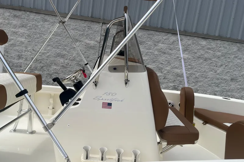 Slide: The Image of 2026 Pioneer 180 Sportfish boat interior with brown seating and steering console. - 13
