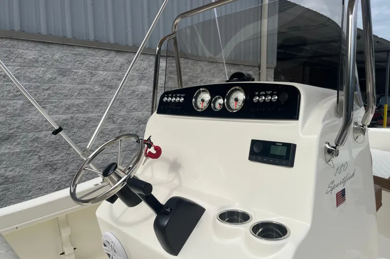 Slide: The Image of 2026 Pioneer 180 Sportfish boat dashboard with steering wheel and gauges. - 16