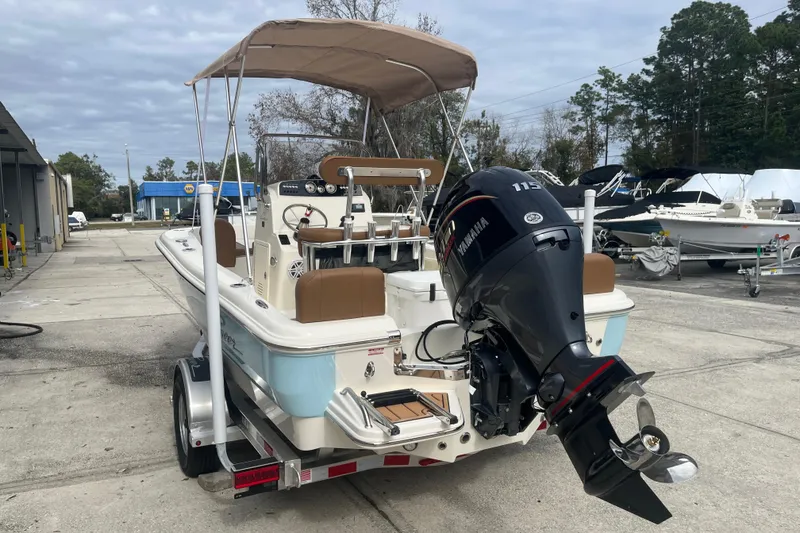 Slide: The Image of 2026 Pioneer 180 Sportfish boat with Yamaha outboard motor on trailer, parked outdoors. - 4