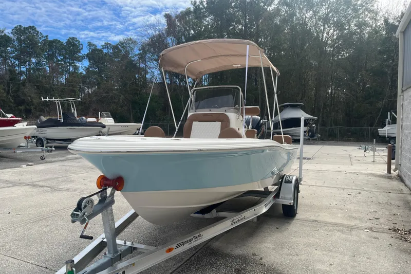 Slide: The Image of 2026 Pioneer 180 Sportfish boat on trailer, parked outdoors under a blue sky. - 6