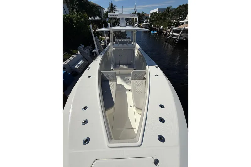 Slide: The Image of 2022 SeaVee 370Z boat with spacious deck and modern design, docked in a marina. - 10