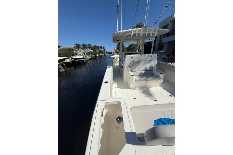 Slide: The Image of 2022 SeaVee 370Z boat docked, featuring spacious deck and seating under clear blue sky. - 14