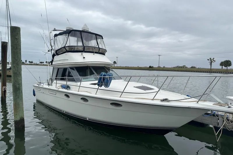 The Image of 1989 Tiara Yachts 3100 Flybridge docked on a cloudy day. - 0