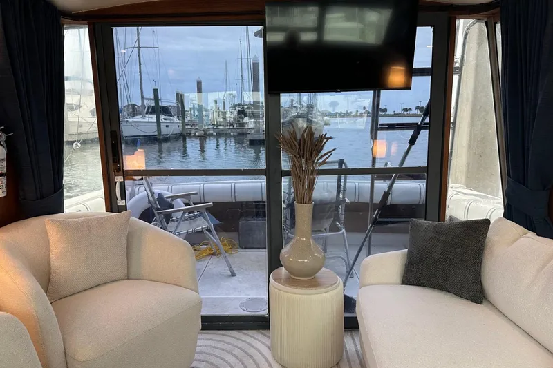 Slide: The Image of Interior of 1989 Tiara Yachts 3100 Flybridge with marina view through glass doors. - 3