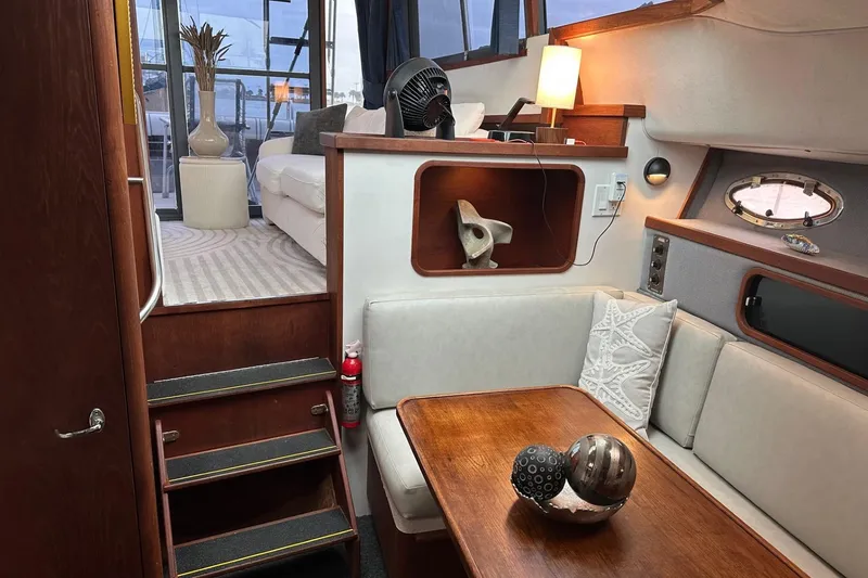 Slide: The Image of 1989 Tiara Yachts 3100 Flybridge interior with cozy seating and elegant decor. - 4