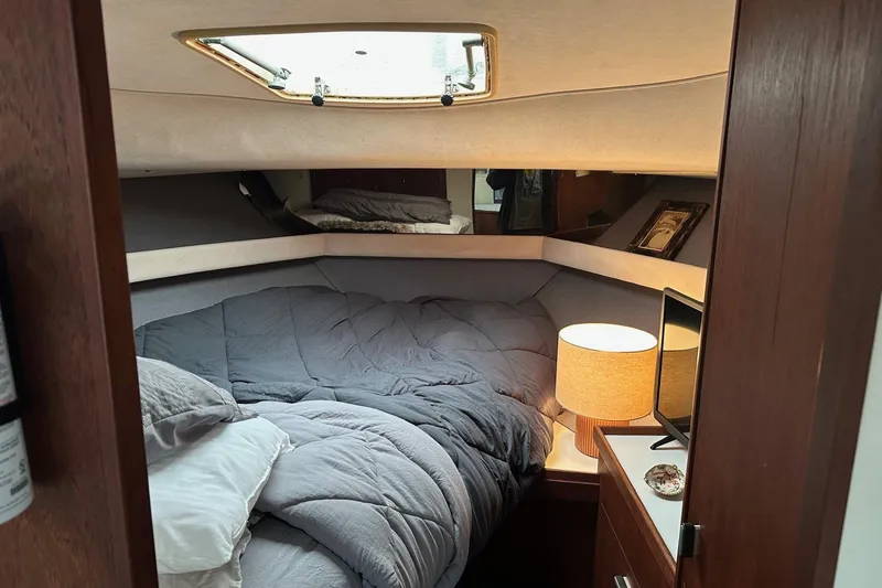 Slide: The Image of Cozy cabin interior of 1989 Tiara Yachts 3100 Flybridge with bed and lamp. - 6