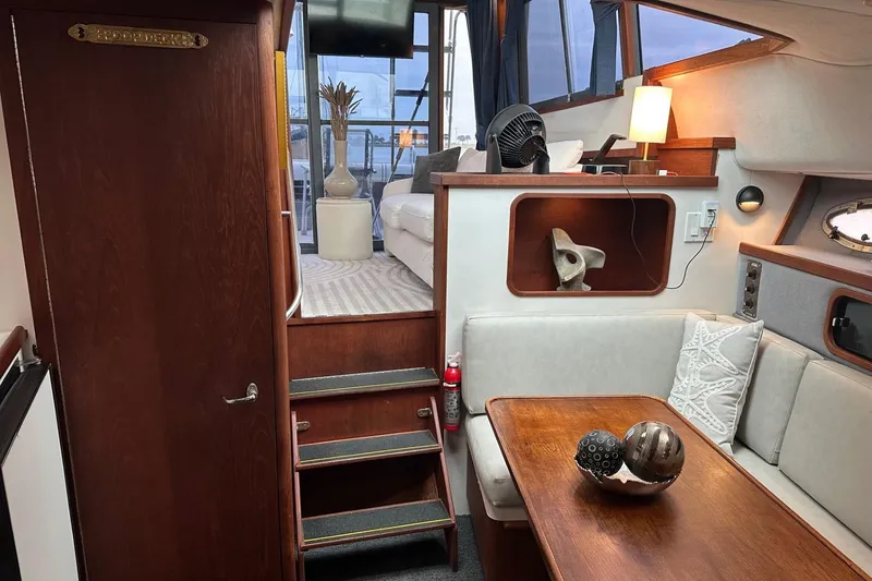 Slide: The Image of Interior of 1989 Tiara Yachts 3100 Flybridge, featuring cozy seating and elegant wooden finishes. - 8