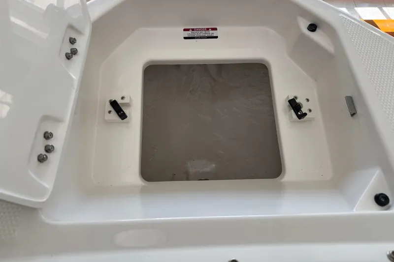 Slide: The Image of 2026 Chaparral 250 OSX boat storage compartment with open hatch, showcasing interior details. - 13