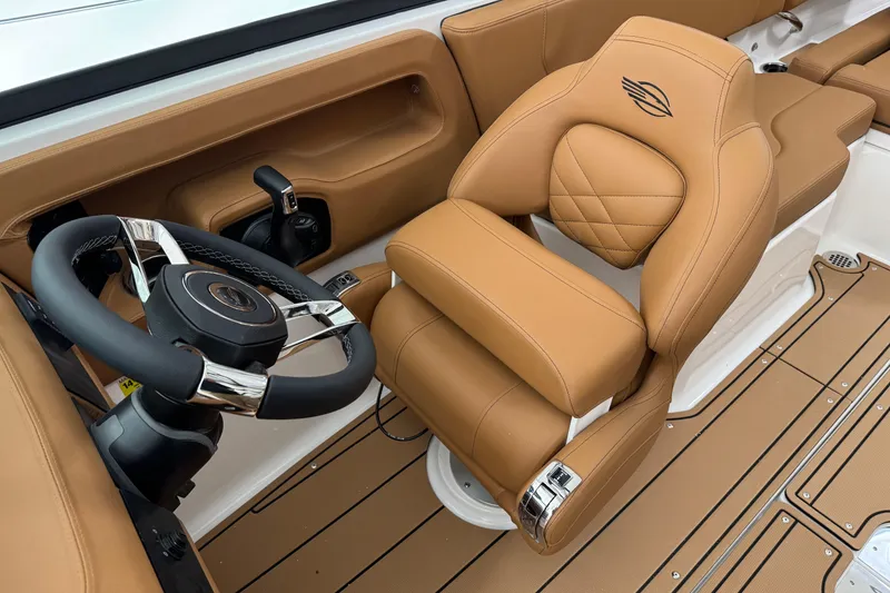 Slide: The Image of Luxurious interior of 2026 Chaparral 250 OSX boat with tan leather seating and steering wheel. - 17