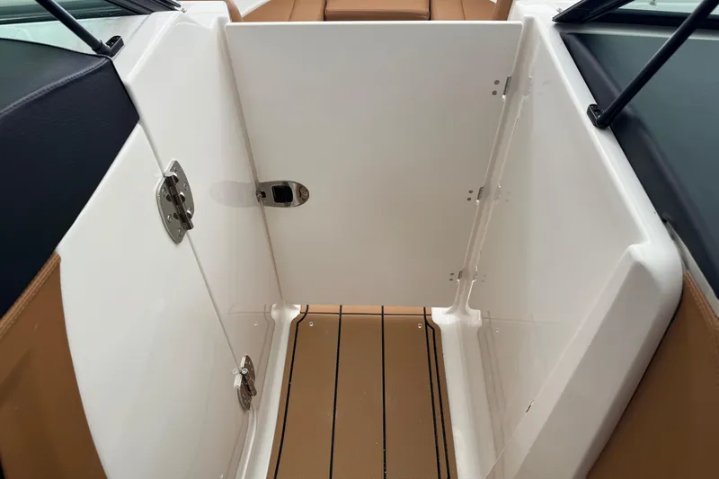 Slide: The Image of 2026 Chaparral 250 OSX boat interior with open storage compartment and sleek design. - 22