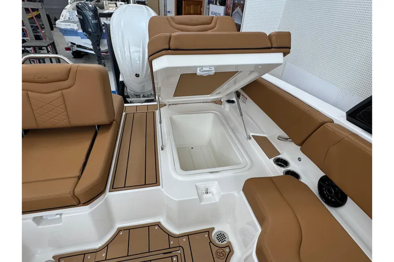 Slide: The Image of 2026 Chaparral 250 OSX boat interior with tan seating and open storage compartment. - 33