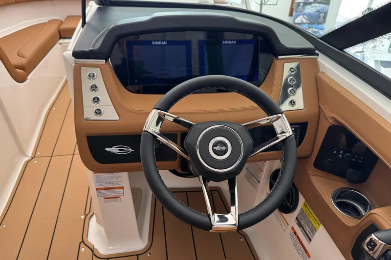 Slide: The Image of 2026 Chaparral 250 OSX boat dashboard with steering wheel and Simrad displays. - 8