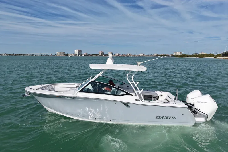 The Image of 2022 Blackfin 272 DC boat cruising on a sunny day with city skyline in background. - 0