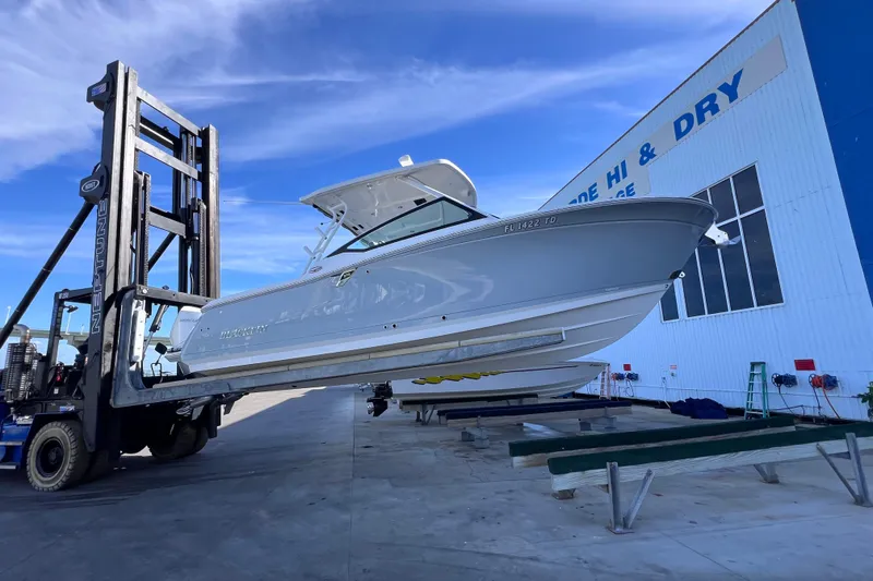 Slide: The Image of 2022 Blackfin 272 DC boat lifted by forklift at marina storage facility. - 102