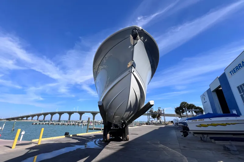 Slide: The Image of 2022 Blackfin 272 DC boat on dock with blue sky and bridge background. - 103