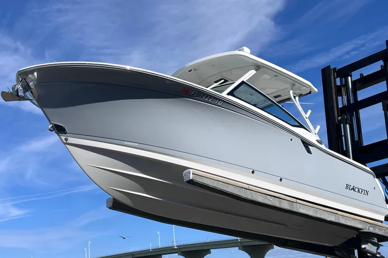 Slide: The Image of 2022 Blackfin 272 DC boat on lift against blue sky background. - 104