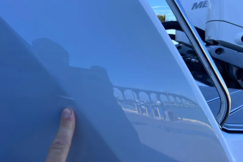 Slide: The Image of Reflection on 2022 Blackfin 272 DC boat hull with finger pointing. - 108
