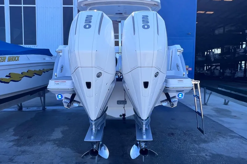Slide: The Image of 2022 Blackfin 272 DC boat with dual outboard engines in a marina setting. - 18