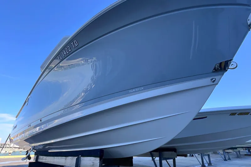 Slide: The Image of 2022 Blackfin 272 DC boat on display under clear blue sky. - 24